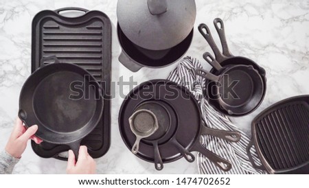Flat lay. Variety of cast iron kitchenware on a marble countertop.