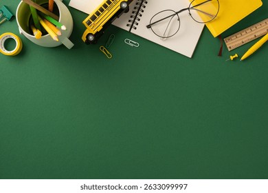 Flat lay of various school supplies on a green desk background emphasizing education and learning