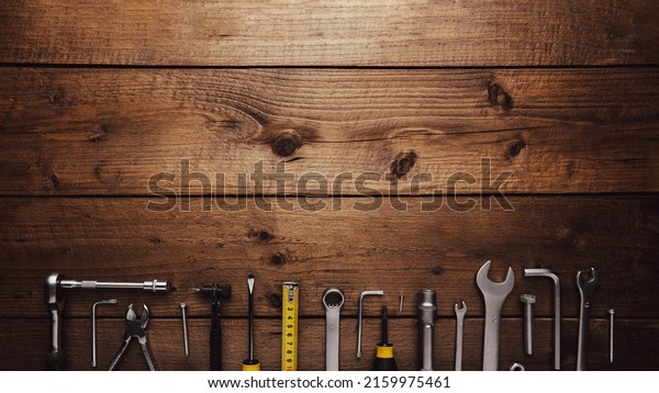Flat lay with various work tools on wooden\
background working table. Top view on new hand tool set for repair,\
construction kit, overhead. Must-have for men. Equipment for\
building. Industry concept