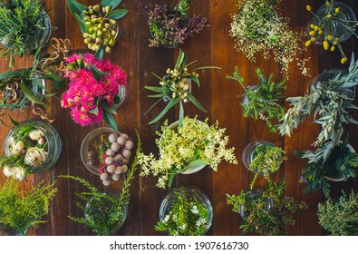 Flat lay of vertical rows of Australian wildflowers on rustic wooden table. 