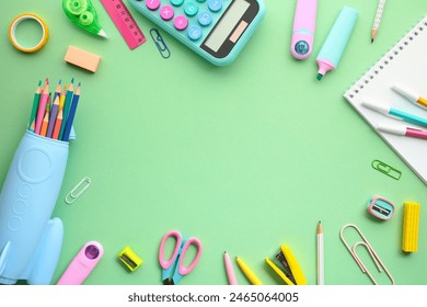 Flat lay of vibrant school or office supplies on a green background. Colored pencils in a blue case, a calculator, and various stationery items. Ideal for educational themes, back to school concept. - Powered by Shutterstock