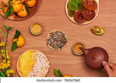 Flat lay Vietnamese new year food and drink on rustic red wooden table top. Text appear in image: Prosperity.