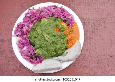 Flat Lay View Of Chicken Rukau Dish Served In A Plate On A Wooden Table In Muri Night Market Rarotonga, Cook Islands.Food Background And Texture. No People. Copy Space