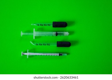 Flat lay view of different glass and plastic droppers to measure small quantities of liquids in millimetres on bright green background