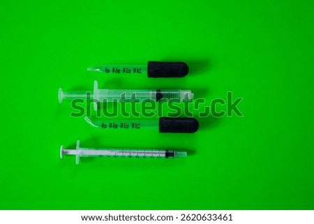 Flat lay view of different glass and plastic droppers to measure small quantities of liquids in millimetres on bright green background