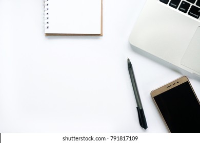 Flat lay view of laptop, smartphone, notepad & pen with copy space on white desk table - Shutterstock ID 791817109