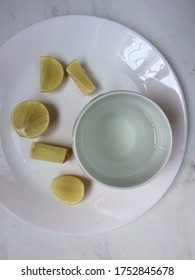 Flat lay view of lime slices and a glass of water on white plate and marble surface , a new normal morning routine and food combining lifestyle