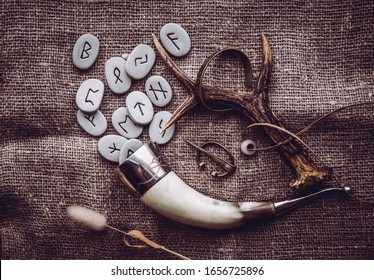 Flat lay view of rune stones with various viking era style objects. Ancient divination and vikings lifestyle concept.