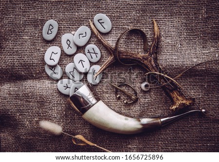 Flat lay view of rune stones with various viking era style objects. Ancient divination and vikings lifestyle concept.