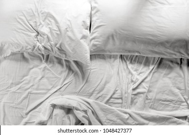 Flat Lay View Of An Unmade Bed In A Bedroom With Two Pillows And Crumpled Bed Sheet, After Waking Up In The Morning. Couple Lifestyle Concept. No People . Copy Space