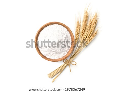 Flat lay of Wheat flour in wooden bowl with wheat spikelets isolated on white background.