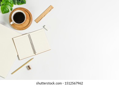 Flat lay of white office desk table with blank notebook, supplies and coffee cup. Top view with copy space. - Shutterstock ID 1512567962