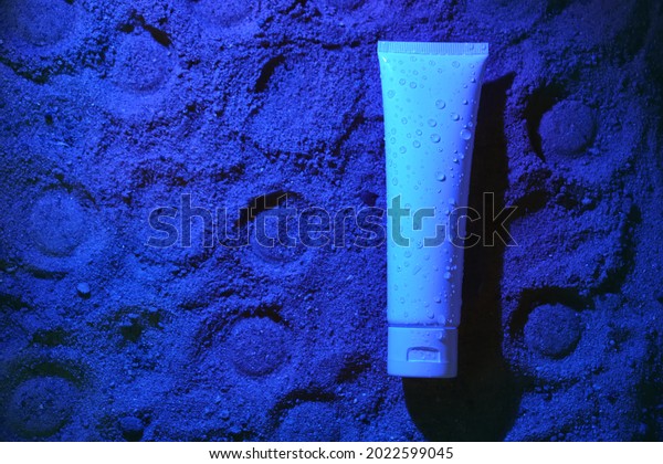 Flat lay. White tube\
of cream on the blue sand, Lunar surface. Mock up. Packaging\
design. Sun protection cosmetics. Body lotion or cream with UV\
protection on beach.\
Natural