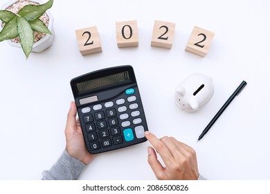 Flat Lay Woman Hands Using Calculator With Number 2022 On White Desk. New Year Goals, Business And Finance Planing Concept. Copy Space, Top View