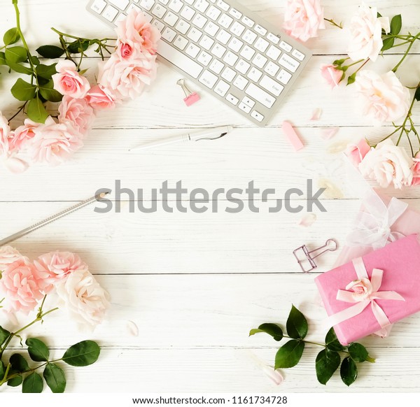フラットなレイで 女性のオフィスデスクの職場と花 木の白い背景に女性のワークスペースとキーボード 花 薄いピンクのバラ 贈り物 アクセサリー 女性の背景にトップビュー コピー用スペース の写真素材 今すぐ編集