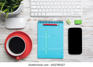 Flat Lay Wooden Desk With Computer Keyboard And Mouse, Mobile Phone And Spiral Notebook With Motivational Crossword. Top View Modern Office Workplace. Business Creativity And Idea Generation Concept