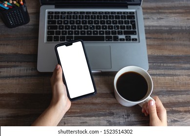Flat lay workspace desk top view: laptop keyboard, phone with a cope space and cup of coffee in hands. Social media break! - Shutterstock ID 1523514302
