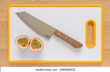 Flat Lay/Flatlay Of A Passionfruit On A White Cutting Board With A Knife