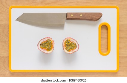 Flat Lay/Flatlay Of A Passionfruit On A White Cutting Board With A Knife