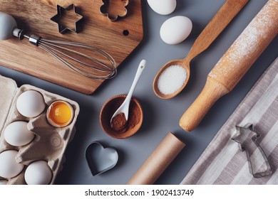 Flat layout composition, baking ingredients and kitchen utensils on a gray background. Culinary trendy background. The concept of making homemade desserts for the holiday.