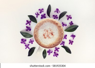 flat layout of frothy cappuccino and a floral pattern desk top view / table setting with aroma of spring