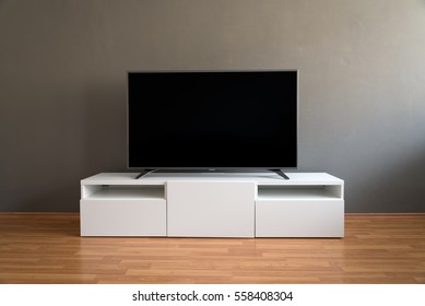 リビングルームの白いキャビネットに平らなLCDテレビ（暗いグレーの壁とパーケットの床付き）