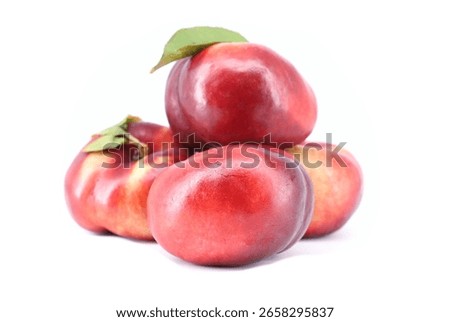 Flat nectarines, also known as rectangular nectarines, on white background. It's a variety of peach.