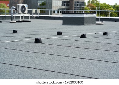 Flat roof covered with bitumen membrane for waterproofing. - Shutterstock ID 1982038100