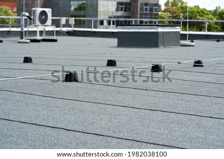 Flat roof covered with bitumen membrane for waterproofing.