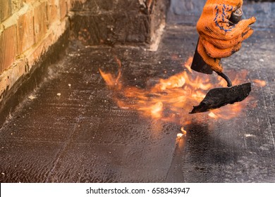 Flat Roof Installation. Heating And Melting Bitumen Roofing Felt. Flat Roof Repairing With Roofing Felt. Roofing Felt. Roofing Repair. Roofer Working.  Roofer Make. Roofer Working Tool. Waterproofing