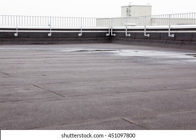 an flat roof with roofing and fencing