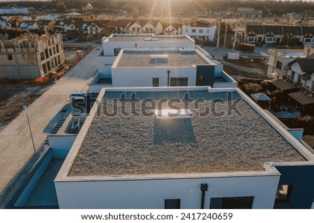 Flat roofs with Gravel on modern houses in an neighbourhood.