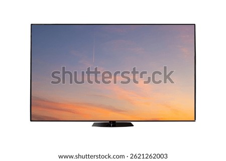 Flat screen TV from angled view with rural landscape with straw roll and sunset sky on screen