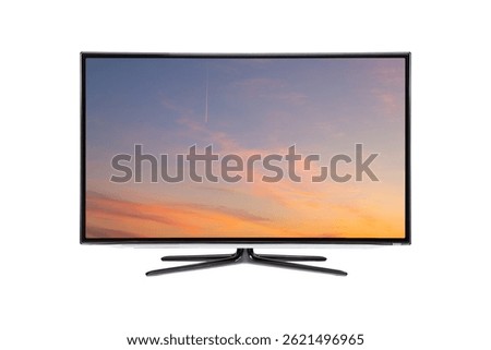 Flat screen TV from angled view with rural landscape with straw roll and sunset sky on screen