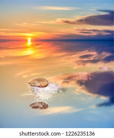 Flat Stone Skipping Across Calm Water At Sunset