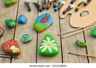 Flat Stones Painted With Acrylic Paints. Do It Yourself. Souvenirs That Children Can Make.