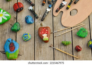 Flat Stones Painted With Acrylic Paints. Do It Yourself. Souvenirs That Children Can Make.