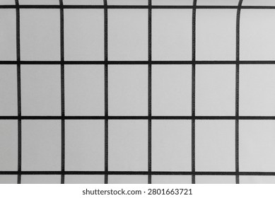 A flat surface shows a grid pattern with dark lines creating squares on a light background. The setup is simple and neat providing a clean look for various uses.