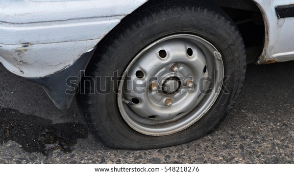 flat tire of a damaged\
parking car