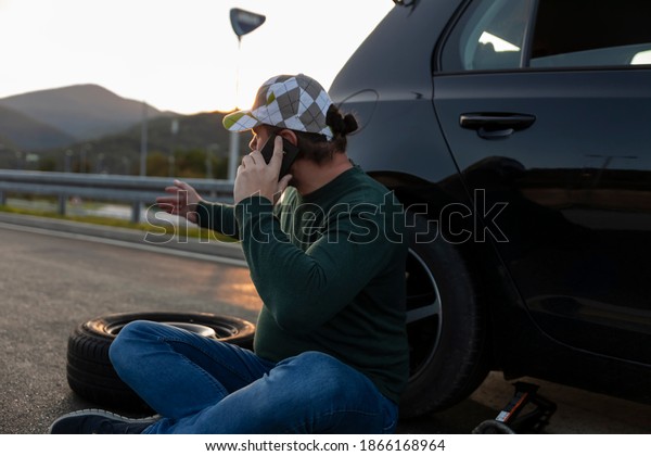 A flat tire, a highway, a man calling for help on
his cell phone