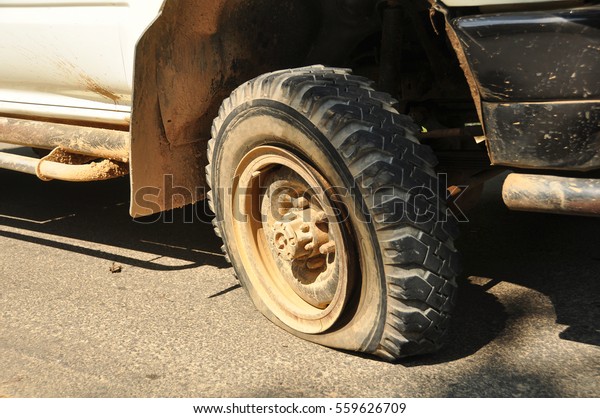 Flat tire and old car on the\
road