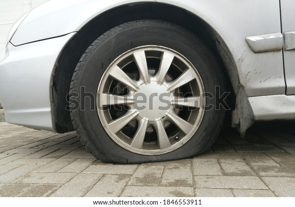 Flat tire\
on a car. Side view Of Damaged Flat\
Tire