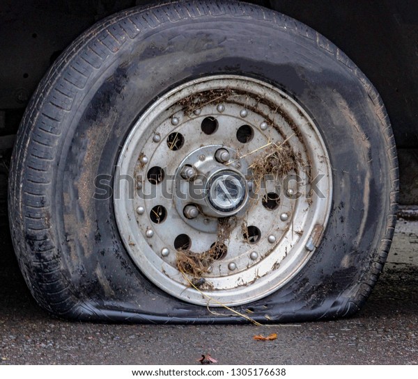 A\
flat tire on a car in the street of Portland,\
Oregon.