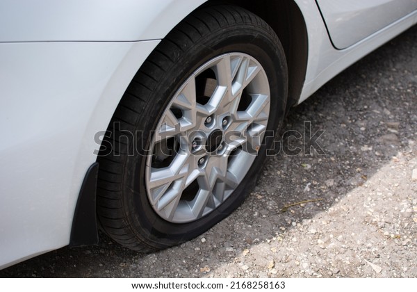 Flat tire on a white car. Passenger car. High\
quality photo
