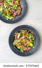 Flat Top View Of 2 Plates Of Asian Beef Salad. Inspired By Thai & Vietnamese Cuisine, This Salad Is Made With Fresh Healthy Vegetables (carrots, Onions, Cucumber, Etc) And A Nicely Seared Flank Steak