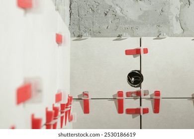 Flat wall plastic tile leveling system. Process of installation of tiles in the bathroom step by step. DIY home improvement.	
