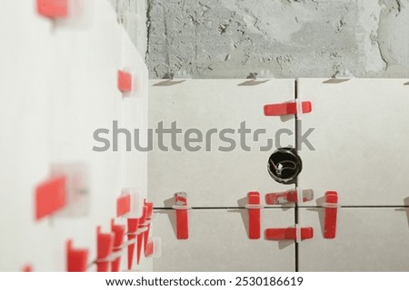 Flat wall plastic tile leveling system. Process of installation of tiles in the bathroom step by step. DIY home improvement.	
