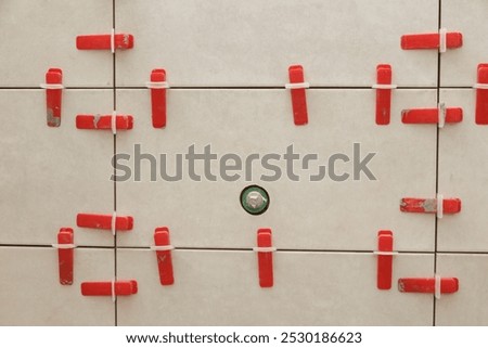 Flat wall plastic tile leveling system. Process of installation of tiles in the bathroom step by step. DIY home improvement.	
