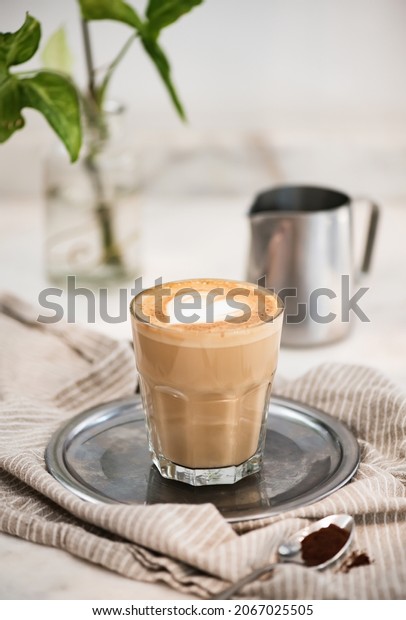 Flat white coffee with heart shaped milk and\
coffee powder