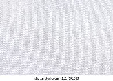Flat white-colored glossy fabric texture background. This fabric is made of 100% polyester.